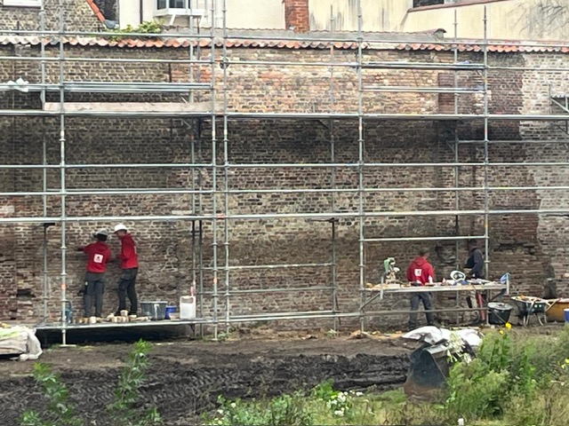 Leerlingen van VTI Brugge helpen met de restauratie van de abdijmuur.