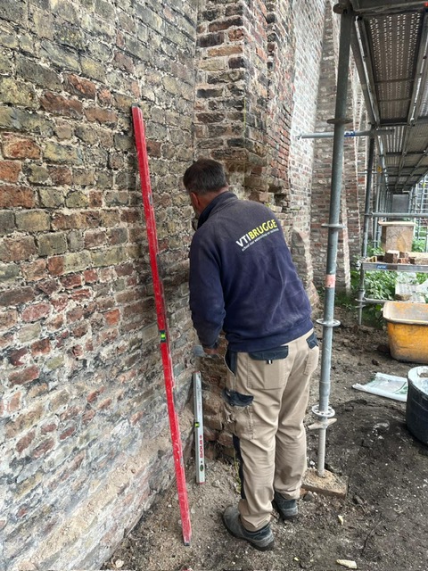 Leerlingen van VTI Brugge helpen met de restauratie van de abdijmuur.